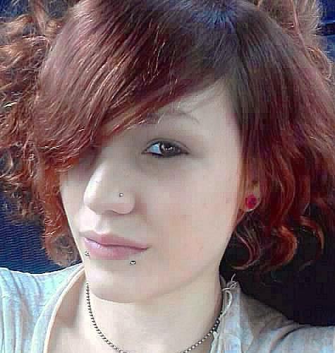 Model with stretched ears, nostril piercing, and lip piercings
