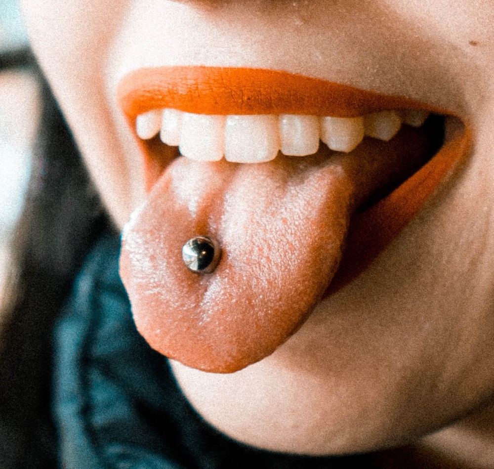Photo of smiling mouth with tongue piercing
