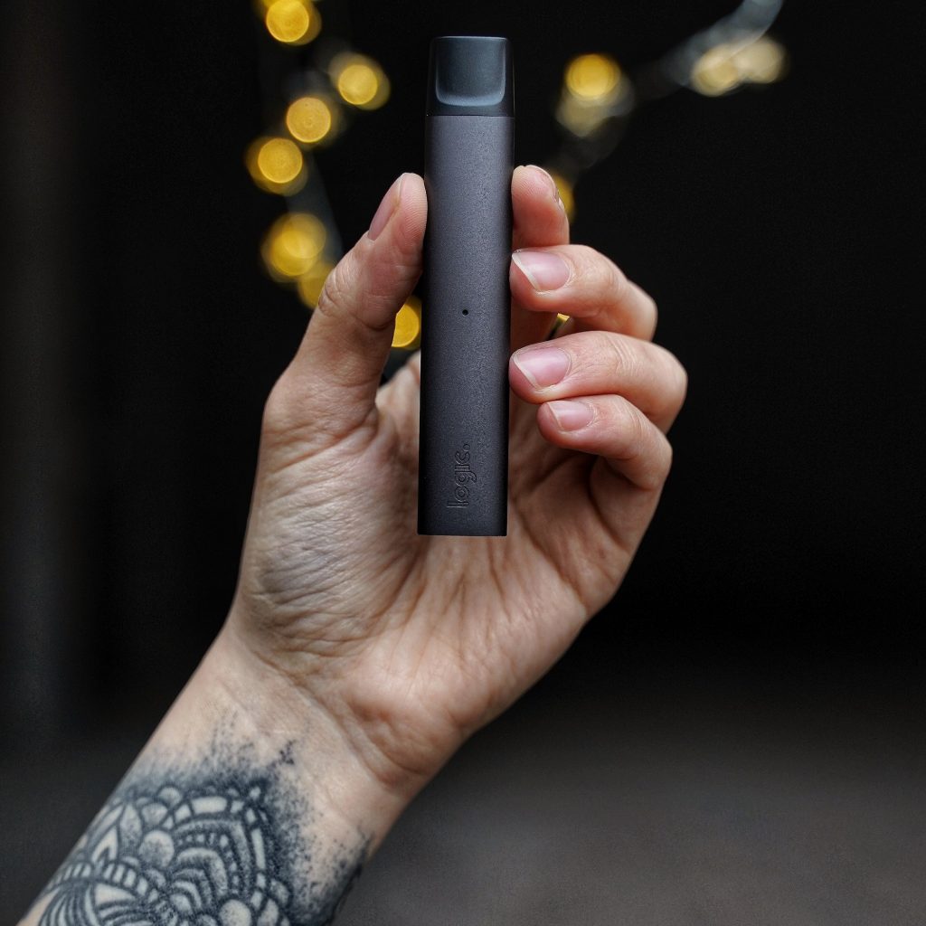 E-cigarette in a tattooed man's hand