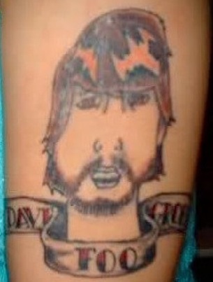Bad Tattoo of Dave Grohl With the Words Dave Foo Grohl in a Banner Beneath 