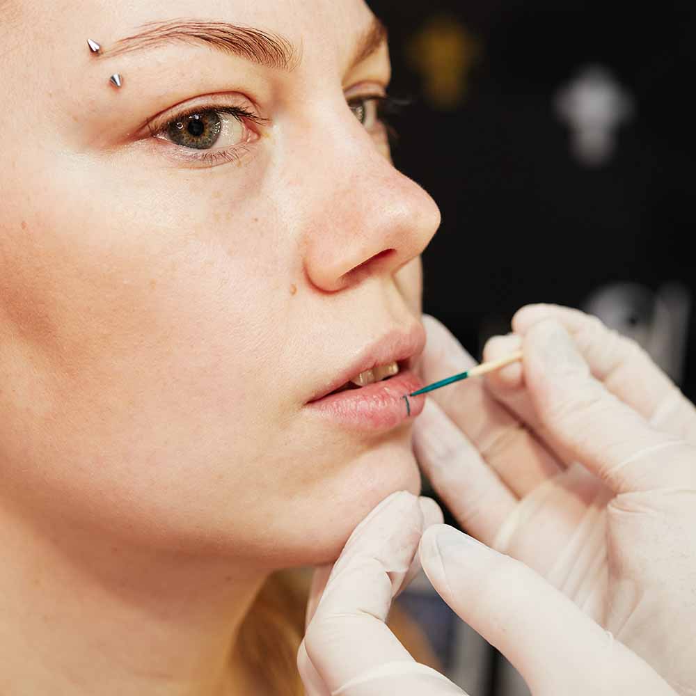 Piercing client getting their bottom lip marked for a lip piercing