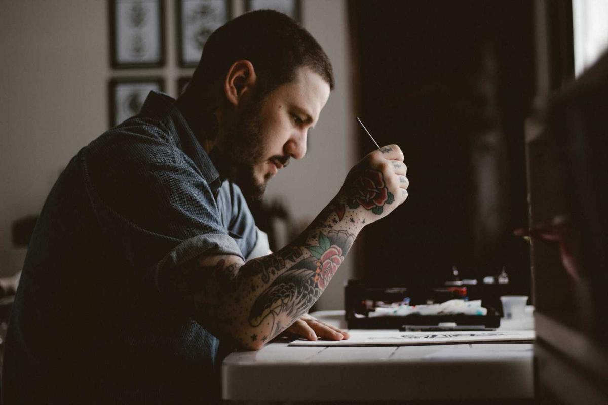 tattoo artist, tattoo artist drawing, man drawing