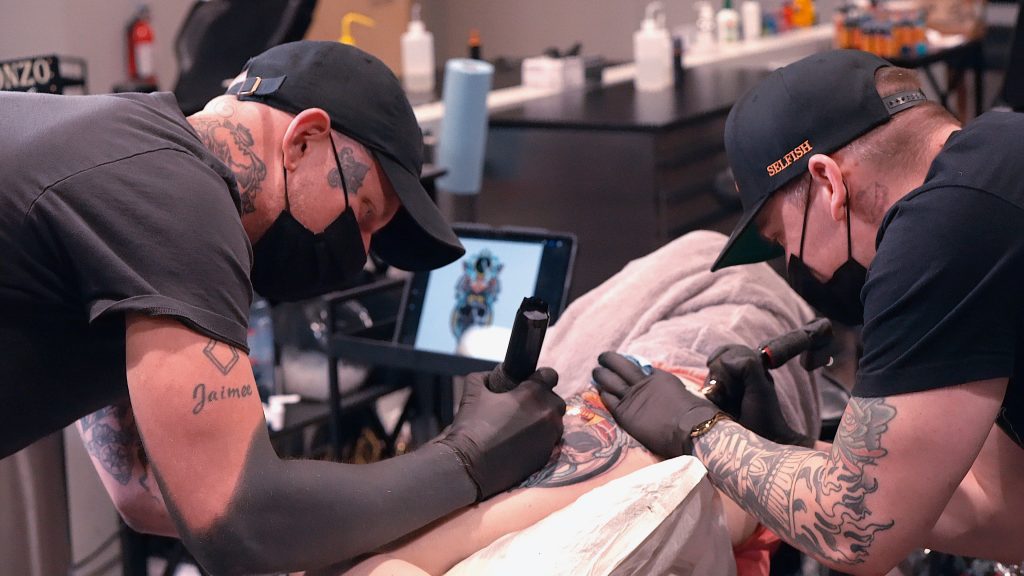 Harlan Kantner and Kasey Gonzalez collaborating on a tattoo