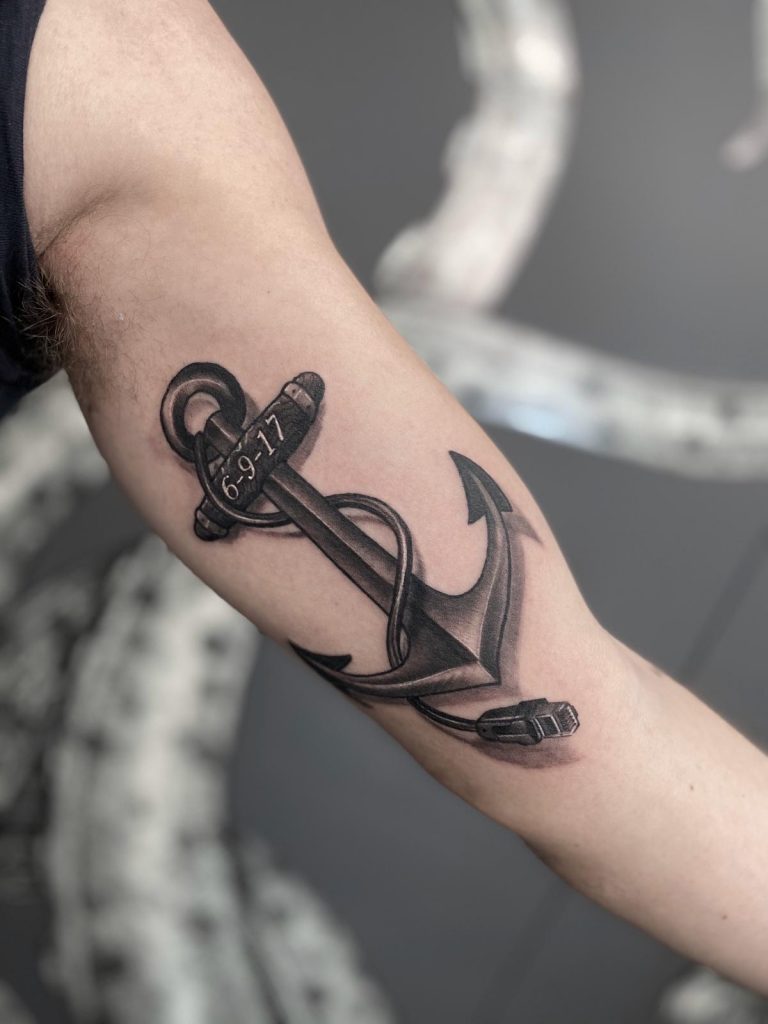 Tattoo of nautical anchor on inner arm