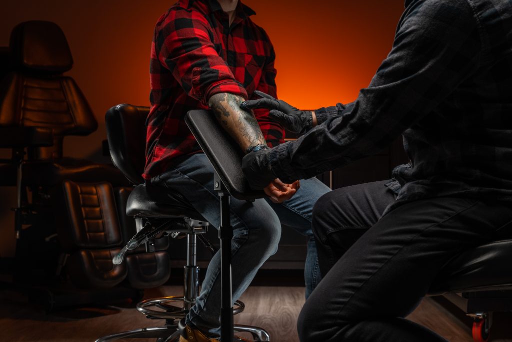 Fellowship portable armrest with client getting an arm tattoo