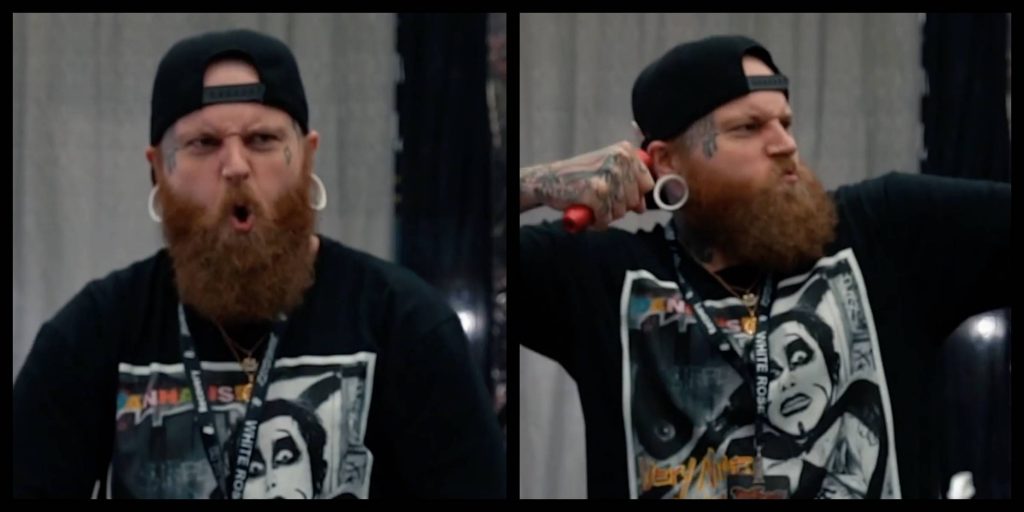 Tattoo artist Bobby Douglas flexing his biceps at a tattoo convention