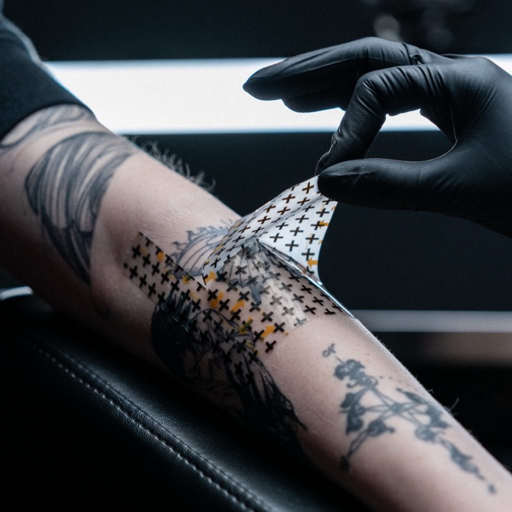 Tattoo client having her bandage removed