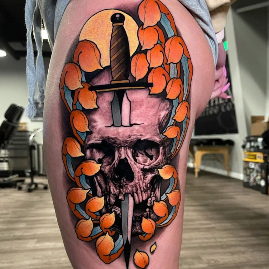 Tattoo client with skull and sword tattoo on thigh