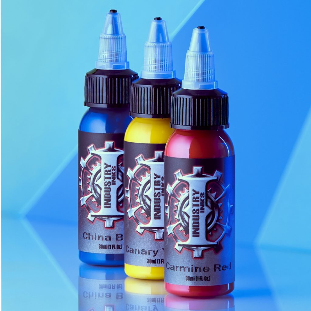 Three Industry Inks tattoo inks on a blue backdrop