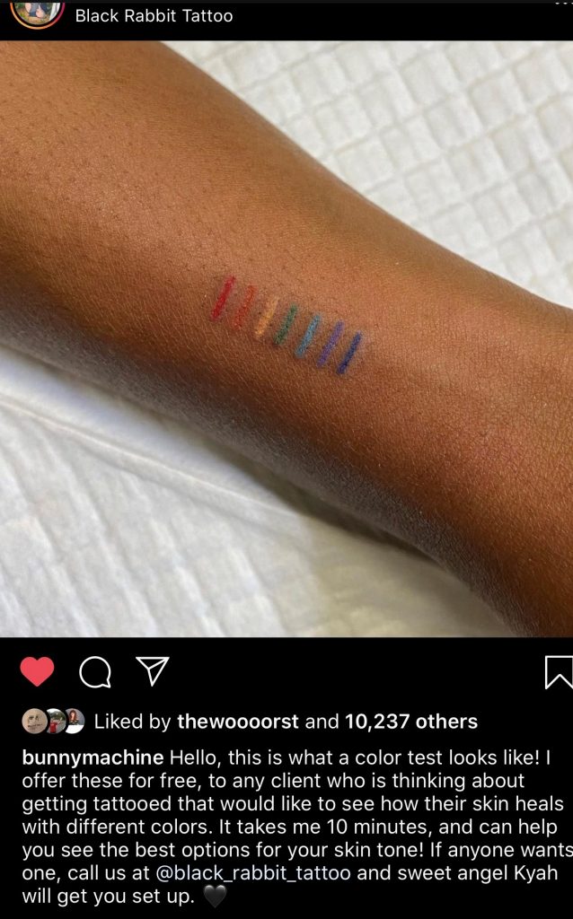 Screenshot of a post by Black Rabbit Tattoo Shop showing a color test on a black person's arm