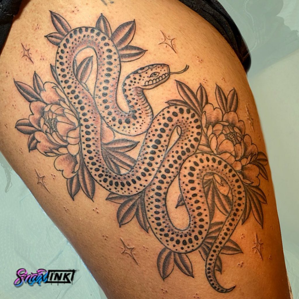 Large-scale black and gray snake tattoo on a black client.
