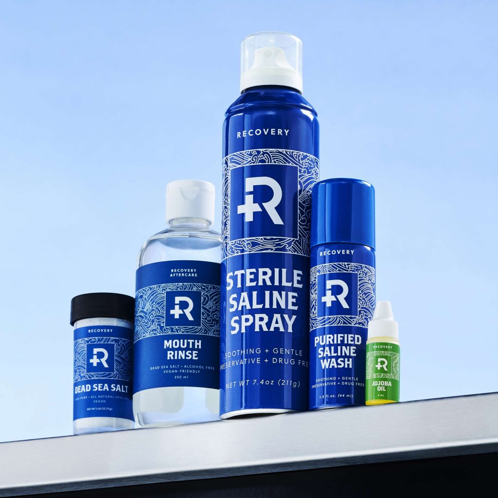 Group shot of Recovery piercing aftercare products on a stainless steel table