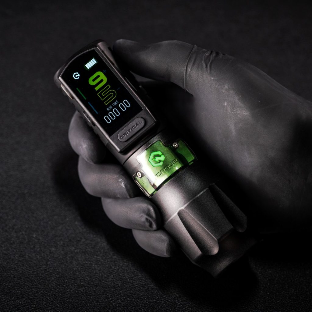 Critical Torque Machine held by a gloved artist hand
